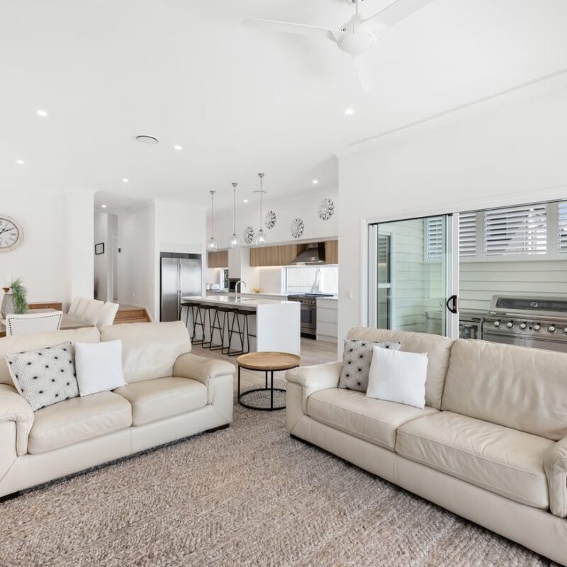 Spacious open-plan living area with a modern kitchen, dining space, and seamless outdoor connection. Designed by Jensen Constructions, Brisbane’s experts in home renovations and extensions.