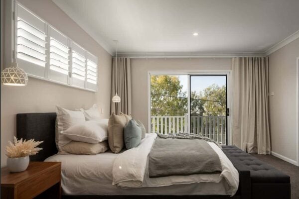 Contemporary bedroom design with soft lighting, floor-to-ceiling curtains, and a plush bed for a relaxing retreat. Brisbane’s Jensen Constructions transforms homes with stylish interior renovations.